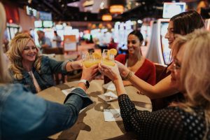 Group of women cheersing their mimosas inside the casino