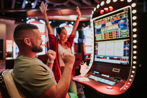 Man and woman celebrating a jackpot win at a slot machine