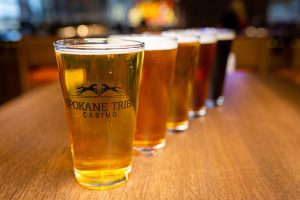Lineup of draft beer in pints with Spokane Tribe Casino logo at Three Peaks restaurant