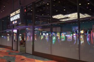 Smoke free gaming area with glass wall and an assortment of slot machines