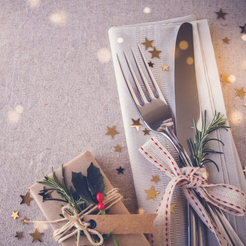 Christmas table place setting, holidays copy space fairy light toning background