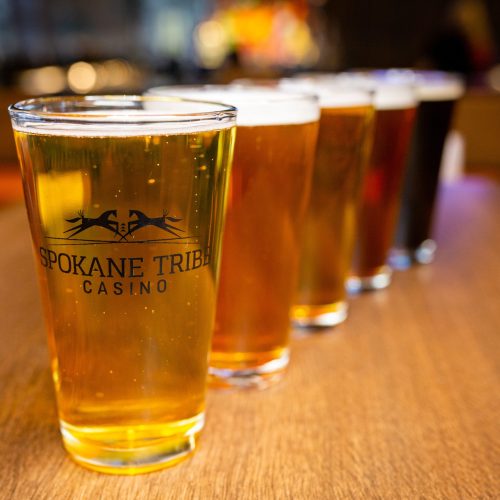 Lineup of draft beer in pints with Spokane Tribe Casino logo at Three Peaks restaurant